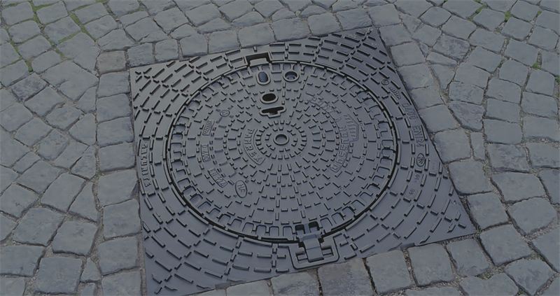 PAM ductile iron manhole cover installed in a cobblestone street